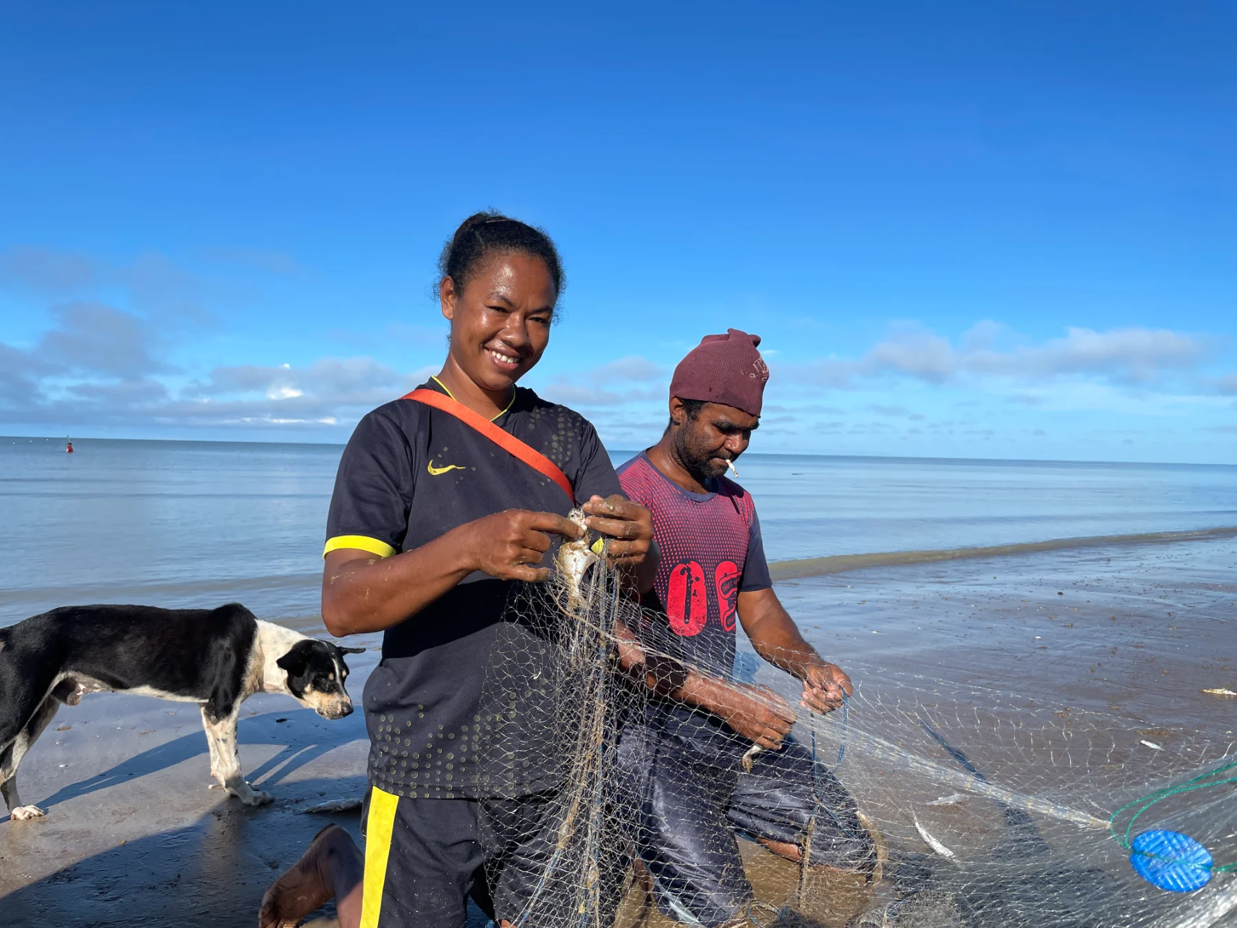 Mama Ester, a woman champion of the BERDAYA program from Kampung Matara, Merauke, works with her husband to pull in a fishing net along the coast. Women like her take part in Sekolah Perempuan while developing coastal-based livelihoods for their families.